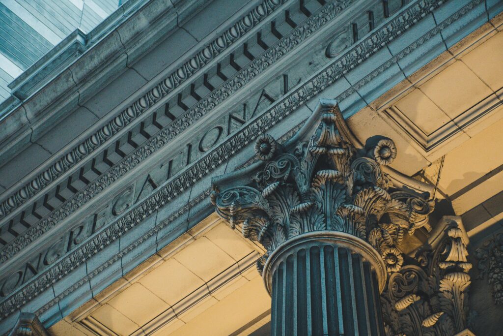 Close-up of a detailed architectural column with ornate designs in an urban setting.